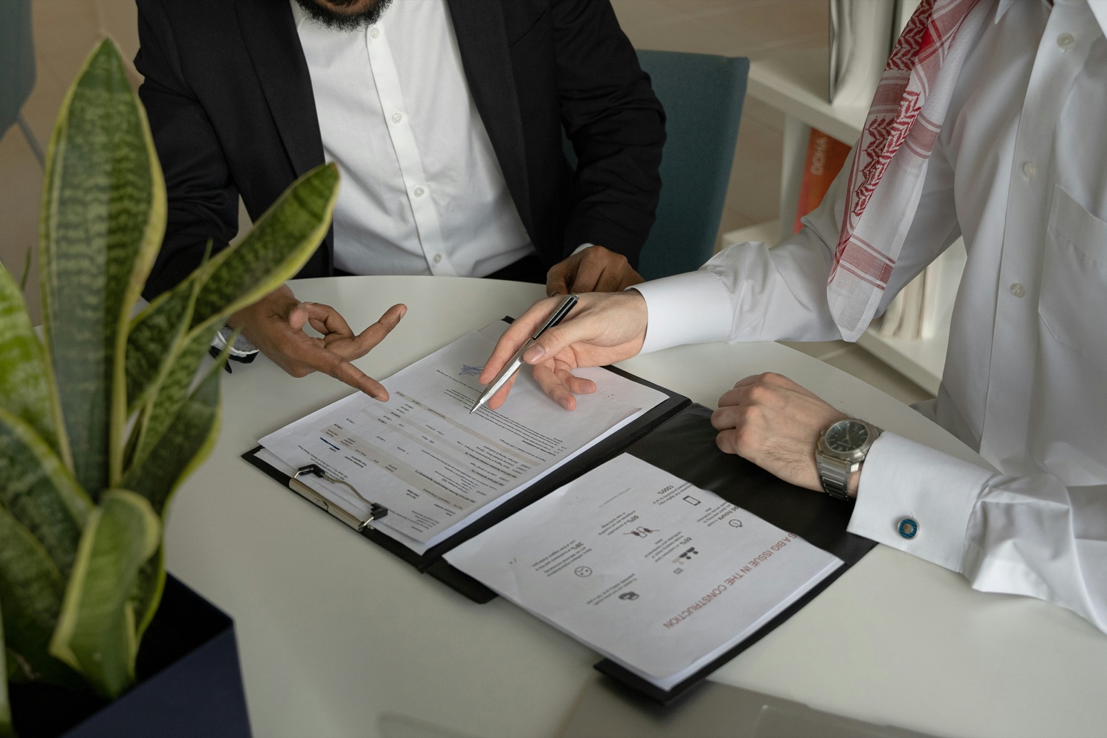 Two people reviewing sale documents together across a table